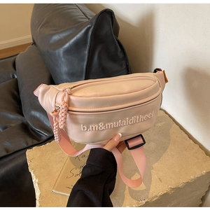 Dettaglio del marsupio in pelle rosa con lettere a rilievo e tiralampo intrecciato rosa