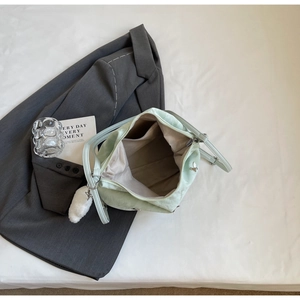 Detail view of mint green nylon bag interior with light gray lining and secure zipper pocket