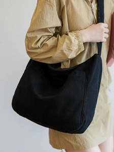 Minimalist large black nylon messenger bag with adjustable wide strap for daily casual wear