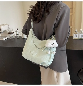 Detail of mint green shoulder bag with silver chain and cute white cloud charm pendant