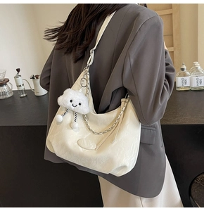 Detail of cream white large capacity hobo bag with textured leather and cloud charm