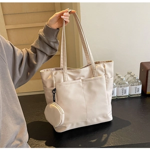 Detail der beigen Nylon-Tragetasche mit praktischen Vordertaschen und Mini-Münzgeldbörse