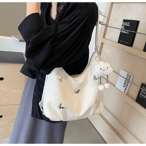 White soft hobo shoulder bag with butterfly metal detail and cloud plush charm