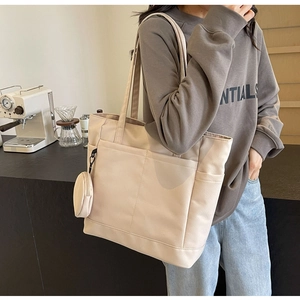 Detail der beigen Nylon-Einkaufstasche mit kleiner Geldbörse und vielen Taschen