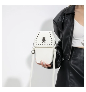 White coffin-shaped crossbody bag with skull emblem and silver rivets on black leather jacket