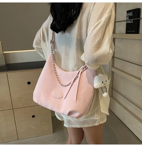 Pink oversized hobo bag with quilted stitching and plush cloud charm detail on a model