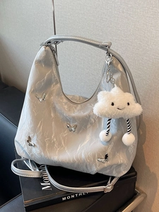 Silver metallic hobo backpack with butterfly charms and a plush cloud keychain accessory
