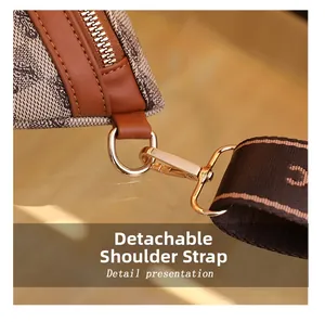 Macro shot of detachable shoulder strap with golden metal clasp and retro pattern detail