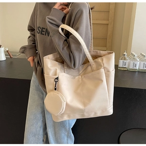 Details einer beigen Nylon-Tragetasche mit Außentaschen und passendem kleinen Münzfach