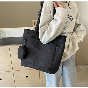 Detailaufnahme einer schwarzen wasserdichten Nylon-Tote-Bag mit Taschen und Mini-Geldbörse
