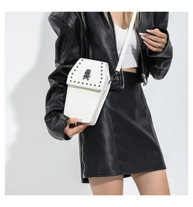 White coffin-shaped crossbody bag with metal skull and studs on female model