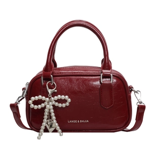 Vintage dark red top-handle bowling bag with pearl bow charm and silver logo