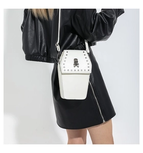 Close-up of white gothic coffin crossbody bag with skull ornament and metal studs