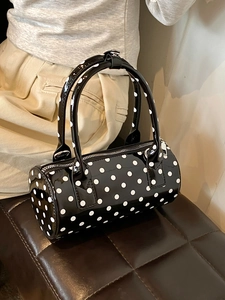 Chic black patent leather Boston bag with white polka dots and silver metal zipper