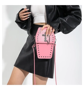 Pink coffin crossbody bag with metal cross and studs detail on a leather outfit model