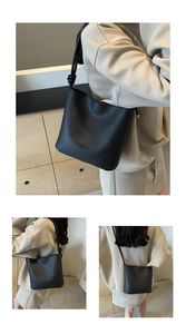 Close-up of black litchi pattern leather bucket bag with knotted shoulder strap detail
