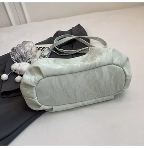 Detail view of mint green shoulder bag featuring marble texture and silver chain strap