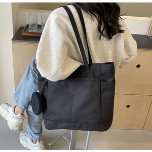 Detailansicht der schwarzen Nylon-Einkaufstasche mit rundem Münzfach in einer Lifestyle-Umgebung