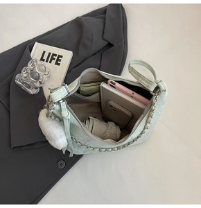 Flat lay of mint green large capacity shoulder bag showing interior storage and accessories