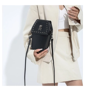 Detail of gothic coffin-shaped crossbody bag with silver skull stud and rivet edges