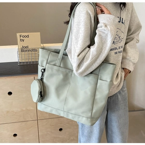 Detail der minzgrünen Nylon-Tragetasche mit Multi-Pocket-Design und runder Geldbörse