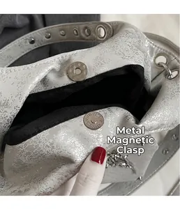 Close-up detail of silver rivet bag showing interior lining and magnetic snap closure