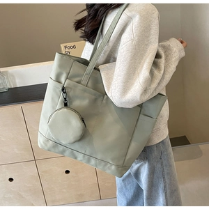 Detail der salbeigrünen Nylon-Tragetasche mit mehreren Taschen und rundem Münzfach