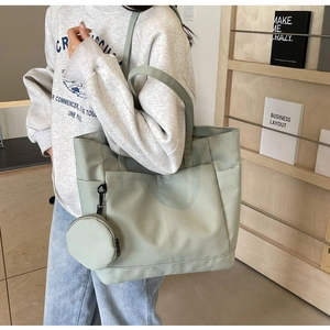 Detail der salbeigrünen Nylon-Tragetasche mit Vordertasche und kleinem rundem Reißverschluss