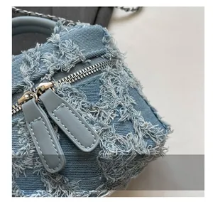Detailed macro view of distressed denim fabric texture and metallic dual-zipper closure