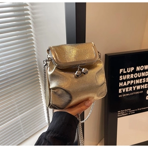 Close-up of golden metallic mini bucket bag with silver chain and bead clasp