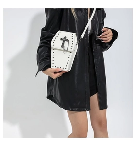 Gothic white coffin crossbody bag with black rivets and large cross detail on a model
