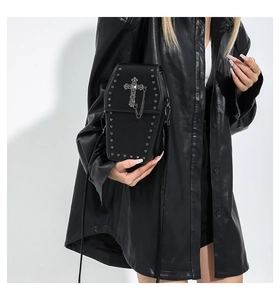 Close-up of gothic coffin-shaped shoulder bag with silver cross, chains and rivet details