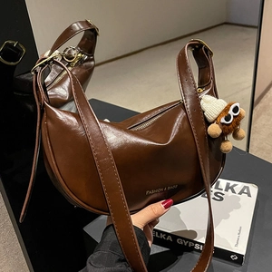 Borsa hobo marrone in pelle a mezzaluna con tracolla larga e ciondolo di peluche