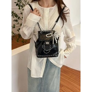 Elegant black chain backpack with pearl bow charm and silver metallic buckle detail
