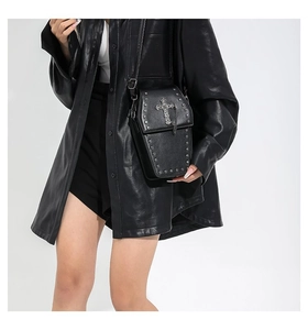 Detail of gothic coffin-shaped crossbody bag with silver cross and metal rivets