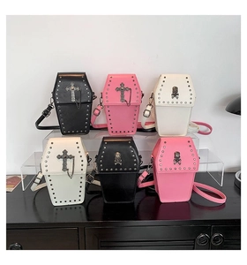Detailed view of punk coffin shaped crossbody bags with metal studs and gothic skull charms