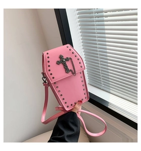 Macro detail of pink coffin-shaped gothic crossbody bag with rivet studs and cross