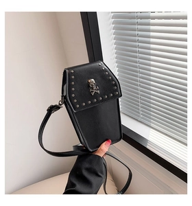 Detail of gothic coffin-shaped crossbody bag with silver studs and metal skull ornament