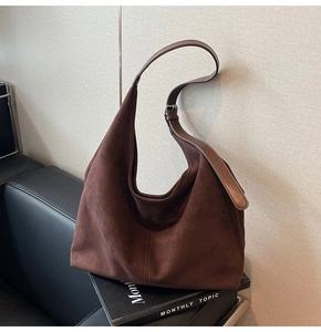 Détail du sac hobo en daim marron avec bandoulière en cuir et coutures rétro