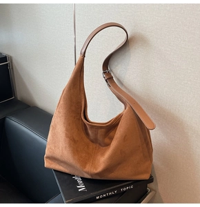 Détail du sac hobo en daim marron avec bandoulière réglable en cuir lisse et boucle