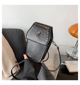 Close-up of a gothic coffin-shaped crossbody bag with silver rivets and metal skull