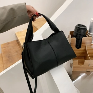 Elegant black lychee grain leather handbag with top handle and adjustable shoulder strap