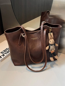 Minimalist deep brown faux leather tote bag with a plush bunny charm and top zipper