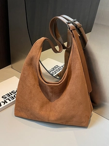Sac fourre-tout en daim marron avec bandoulières en cuir sur fond minimaliste
