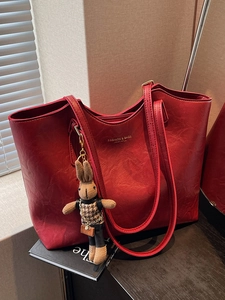 Minimalist red faux leather tote bag with gold lettering and cute bunny charm accessory