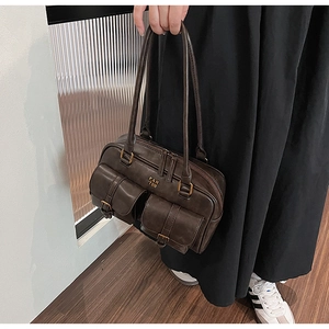 Detail of dark brown Boston bag featuring dual front pockets and vintage gold hardware