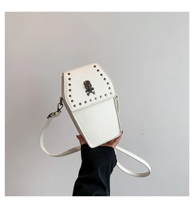 White coffin-shaped crossbody bag with metal skull ornament and studded details
