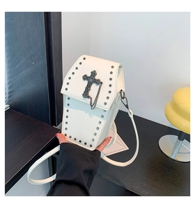 Detail of white coffin shaped crossbody bag with gothic metal cross and studs decoration
