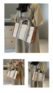 Detail view of canvas tote bag with brown leather trim and striped detachable shoulder strap