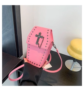 Detailed macro shot of gothic pink coffin cross bag with rivets and metal chain link
